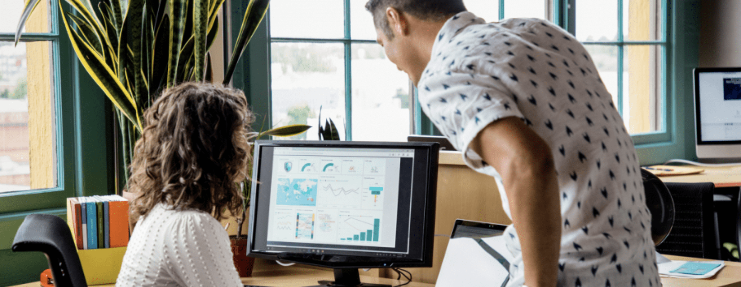 Man and woman looking at a computer screen with Microsoft Dynamics 365 Business Central on it.