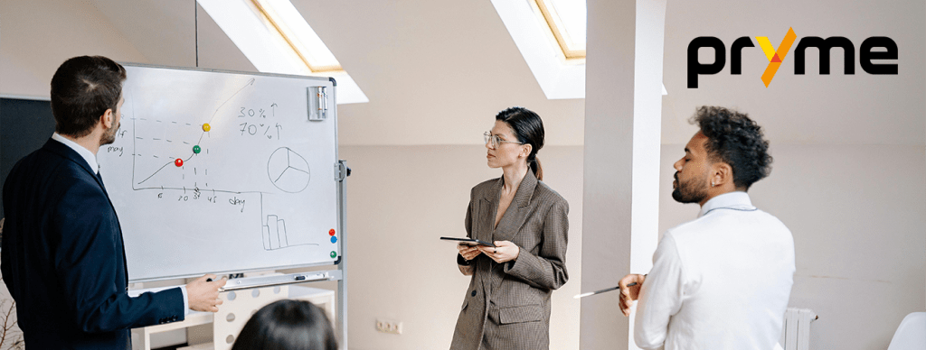 People looking at a whiteboard with a Pryme logo in the top corner