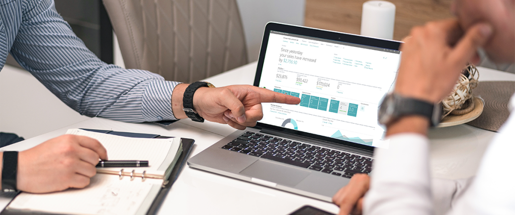 A person pointing at a laptop with Microsoft Dynamics 365 Business Central on the screen