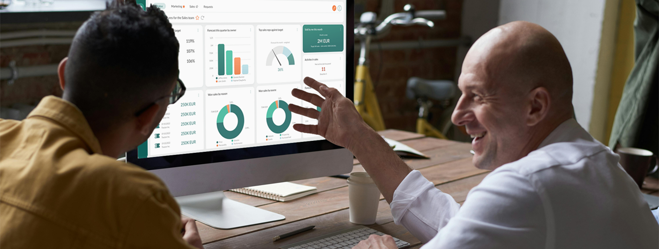 A man showing another man CRM software on a screen