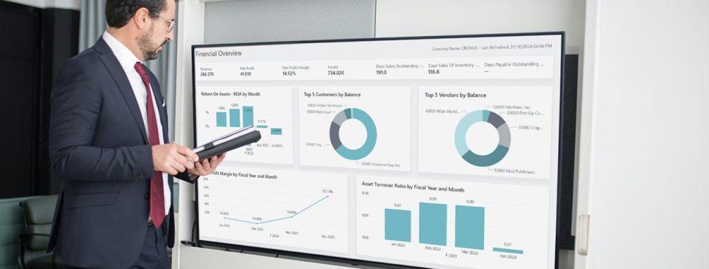 Man looking at a Dynamics 365 Business Central dashboard on a large screen.