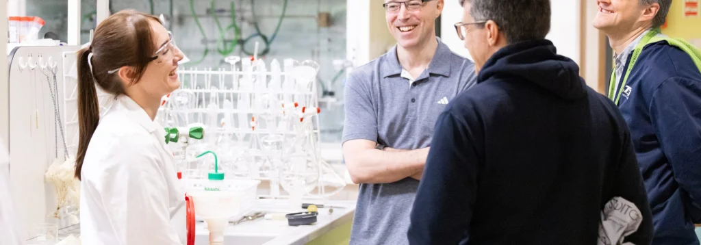 Woman scientist laughing with a group of people in a lab in Apollo Therapeutics